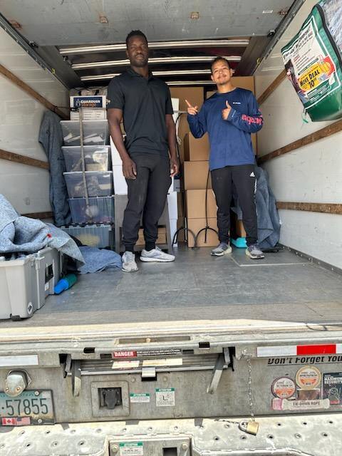2 men standing inside truck